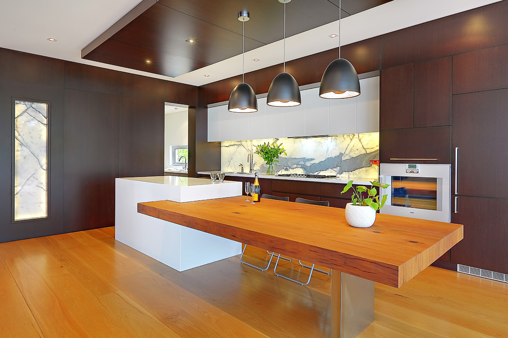 Photo of a contemporary single-wall kitchen in Sydney with white splashback and stone slab splashback.