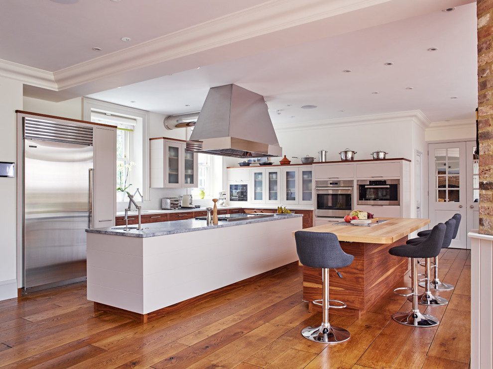Offene, Geräumige Moderne Küche mit flächenbündigen Schrankfronten, Küchengeräten aus Edelstahl und zwei Kücheninseln in London
