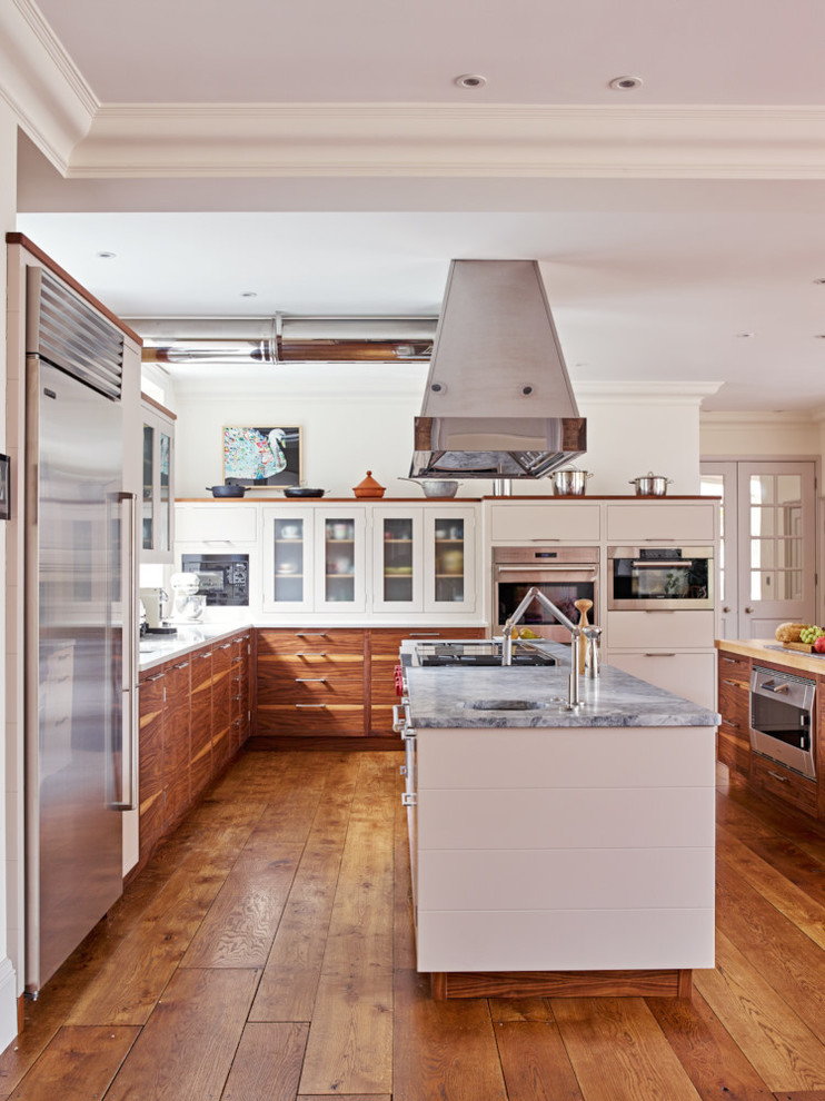 Foto de cocina moderna extra grande abierta con armarios con paneles lisos, electrodomésticos de acero inoxidable y dos o más islas