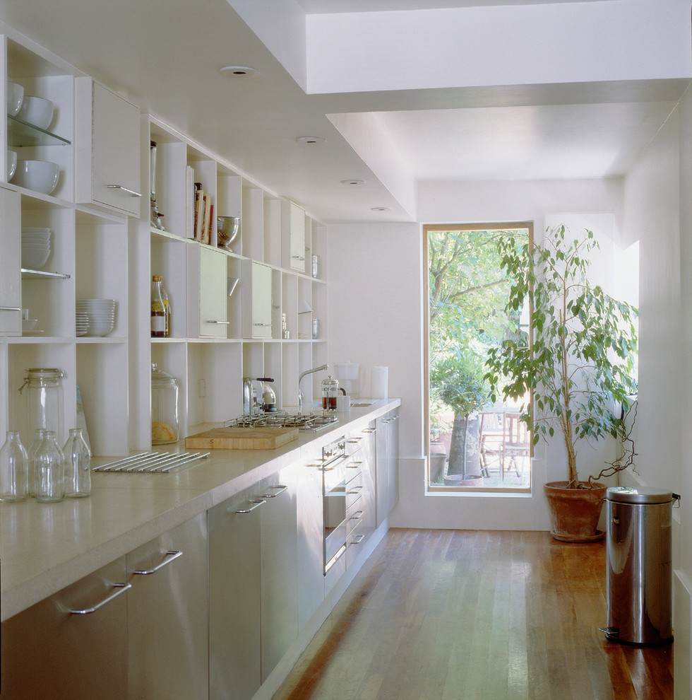Kleine, Einzeilige Moderne Wohnküche ohne Insel mit offenen Schränken, weißen Schränken, Betonarbeitsplatte und braunem Holzboden in Sonstige