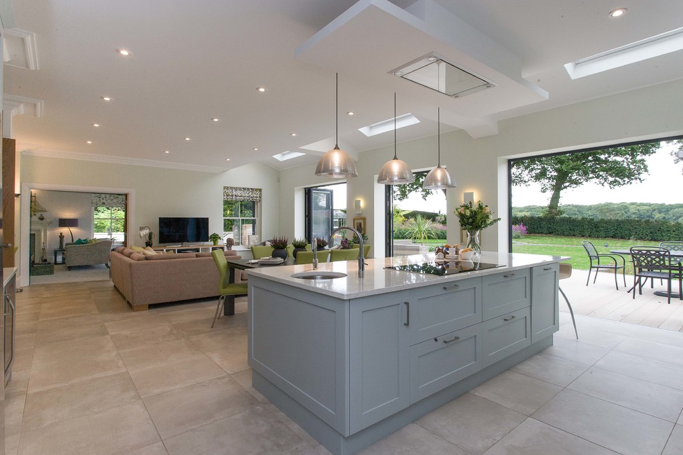 Example of a large transitional l-shaped limestone floor and gray floor eat-in kitchen design in Surrey with a double-bowl sink, shaker cabinets, blue cabinets, quartzite countertops, black appliances and an island