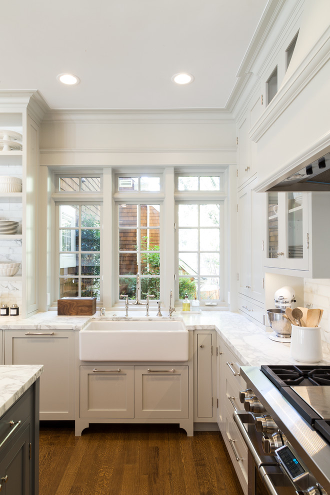Example of a large beach style medium tone wood floor eat-in kitchen design in San Francisco with a farmhouse sink, open cabinets, white backsplash, stainless steel appliances and an island