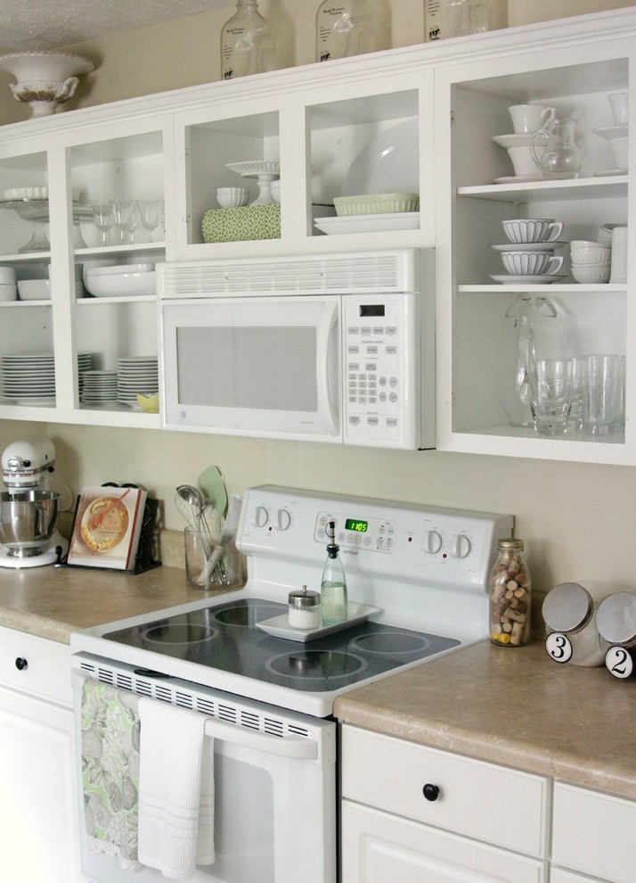 Modelo de cocina clásica con armarios abiertos, puertas de armario blancas y electrodomésticos blancos