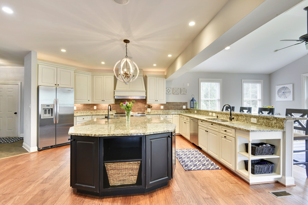 Inspiration for a huge timeless l-shaped medium tone wood floor and brown floor kitchen remodel in Baltimore with a double-bowl sink, raised-panel cabinets, white cabinets, granite countertops, brown backsplash, brick backsplash, white appliances and an island