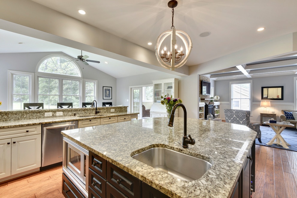 Kitchen - huge traditional l-shaped medium tone wood floor and brown floor kitchen idea in Baltimore with a double-bowl sink, raised-panel cabinets, white cabinets, granite countertops, brown backsplash, brick backsplash, white appliances and an island