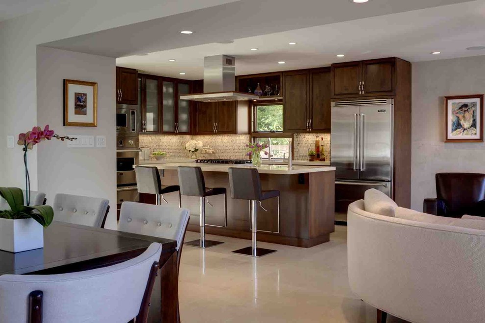 Mid-sized elegant l-shaped limestone floor eat-in kitchen photo in Los Angeles with an undermount sink, raised-panel cabinets, dark wood cabinets, quartz countertops, multicolored backsplash, glass tile backsplash, stainless steel appliances and an island