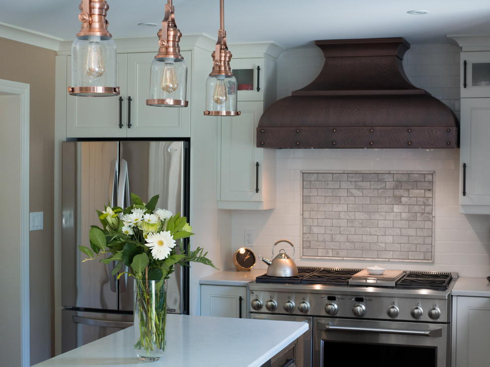 Klassische Wohnküche in L-Form mit Kücheninsel, weißen Schränken, gebeiztem Holzboden und braunem Boden in Toronto