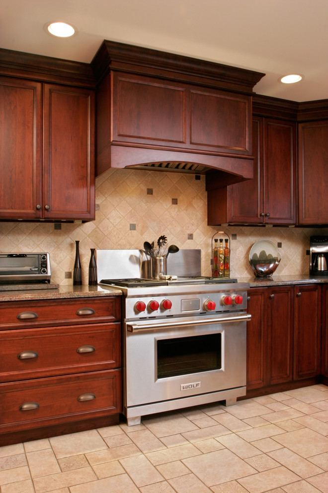 Bild på ett mellanstort vintage kök, med en undermonterad diskho, skåp i mörkt trä, stänkskydd i stenkakel, rostfria vitvaror, klinkergolv i keramik, luckor med infälld panel och beige stänkskydd