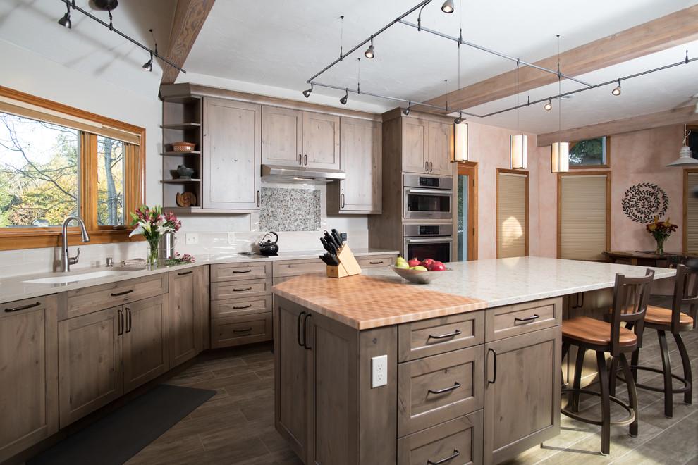 Exempel på ett mellanstort rustikt beige beige kök, med en undermonterad diskho, luckor med infälld panel, grå skåp, bänkskiva i kvarts, beige stänkskydd, stänkskydd i keramik, rostfria vitvaror, klinkergolv i porslin, en köksö och brunt golv