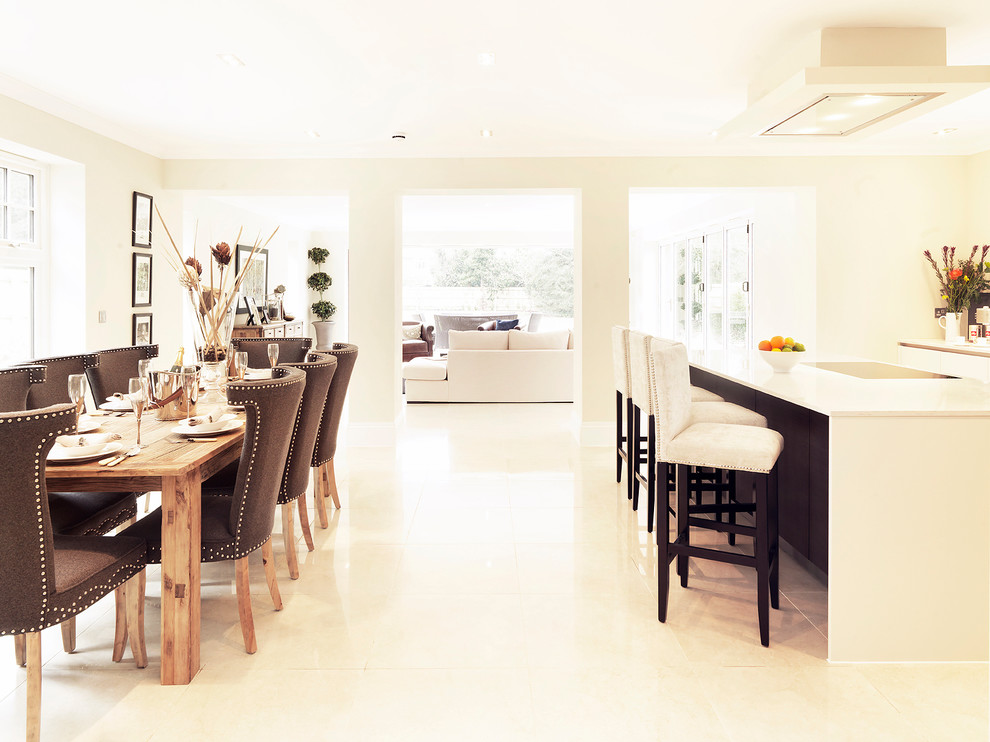 Transitional open concept kitchen photo in Hampshire with white cabinets and an island