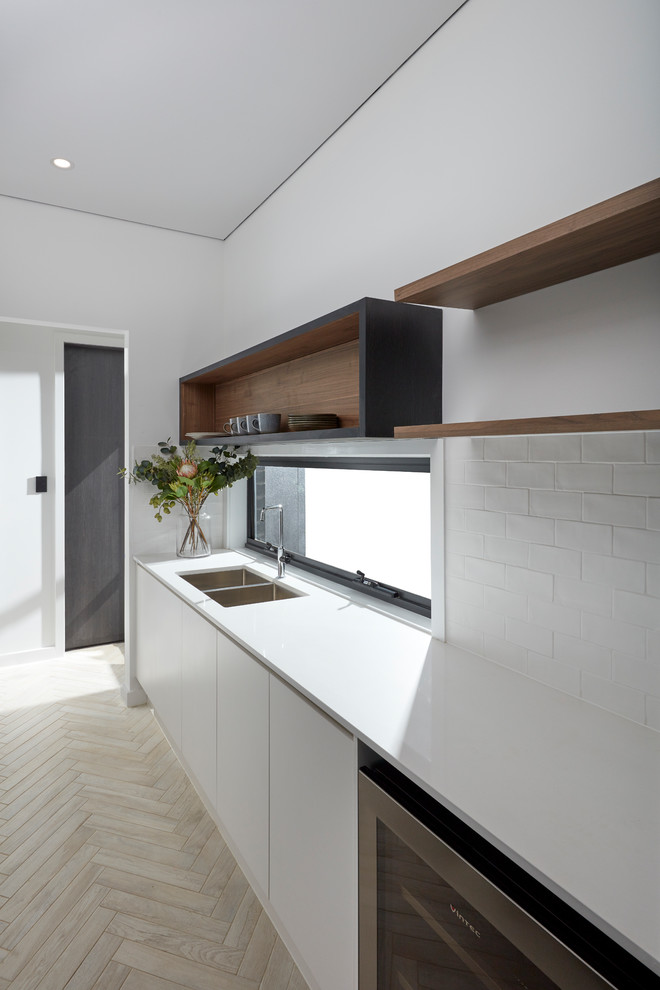 シドニーにある低価格の小さなコンテンポラリースタイルのおしゃれなII型キッチン (白いキッチンパネル、セラミックタイルのキッチンパネル、シルバーの調理設備、セラミックタイルの床、ベージュの床、白いキッチンカウンター) の写真