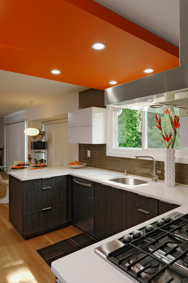 Example of a small trendy u-shaped light wood floor eat-in kitchen design in DC Metro with an undermount sink, flat-panel cabinets, dark wood cabinets, quartzite countertops, beige backsplash, glass tile backsplash, stainless steel appliances and no island
