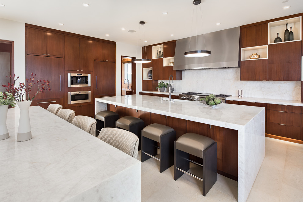 Mid-sized trendy l-shaped ceramic tile and beige floor open concept kitchen photo in Orange County with a farmhouse sink, flat-panel cabinets, dark wood cabinets, marble countertops, white backsplash, stone slab backsplash, stainless steel appliances and two islands