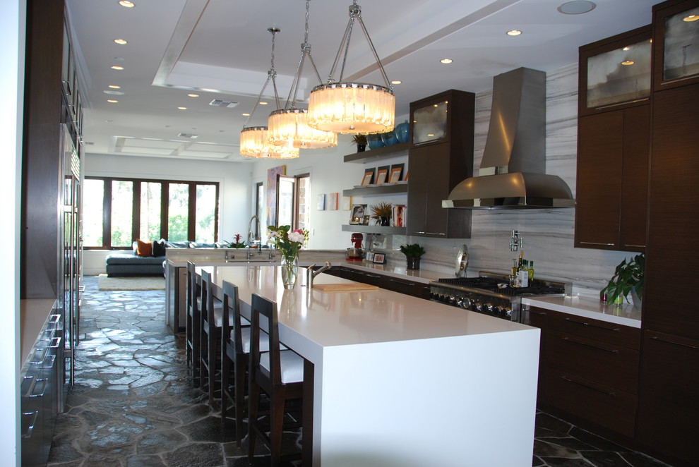 Example of a large trendy galley slate floor eat-in kitchen design in Orange County with an undermount sink, flat-panel cabinets, dark wood cabinets, quartz countertops, gray backsplash, stone slab backsplash, stainless steel appliances and an island