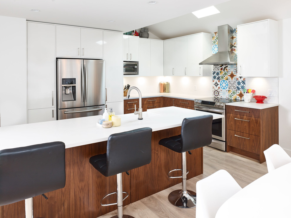 Large mid-century modern l-shaped light wood floor open concept kitchen photo in Vancouver with an island, a farmhouse sink, flat-panel cabinets, dark wood cabinets, multicolored backsplash, ceramic backsplash and stainless steel appliances