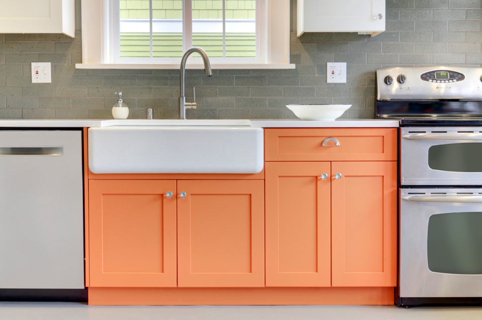 Inredning av ett modernt mellanstort vit vitt kök, med en rustik diskho, skåp i shakerstil, orange skåp, bänkskiva i koppar, grått stänkskydd, stänkskydd i tunnelbanekakel, rostfria vitvaror och grått golv