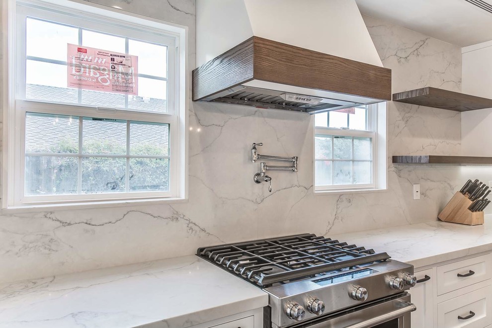 Example of a mid-sized trendy u-shaped porcelain tile and brown floor eat-in kitchen design in Orange County with an undermount sink, recessed-panel cabinets, white cabinets, quartz countertops, white backsplash, stone slab backsplash, stainless steel appliances, an island and white countertops