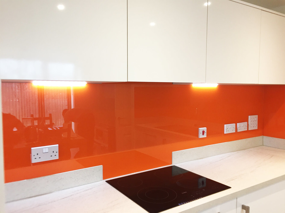 Esempio di una grande cucina abitabile moderna con ante lisce, ante bianche, top in marmo, paraspruzzi arancione, paraspruzzi con lastra di vetro e nessuna isola