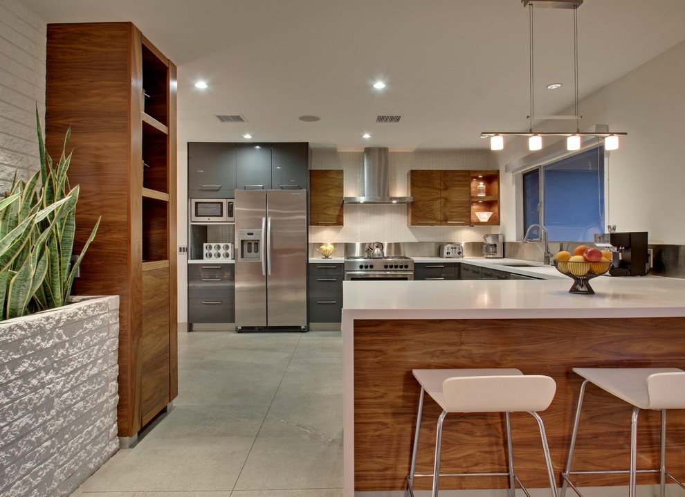 Example of a large mid-century modern u-shaped eat-in kitchen design in Los Angeles with an undermount sink, flat-panel cabinets, gray cabinets, metallic backsplash, stainless steel appliances and an island