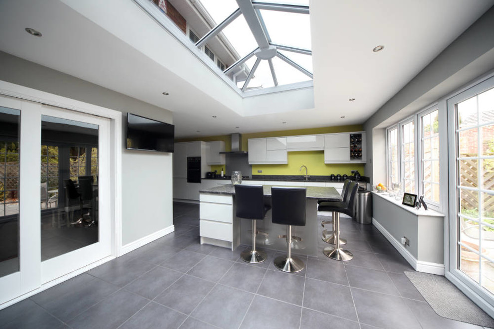 Einzeilige Moderne Wohnküche mit flächenbündigen Schrankfronten, weißen Schränken und Kücheninsel in West Midlands