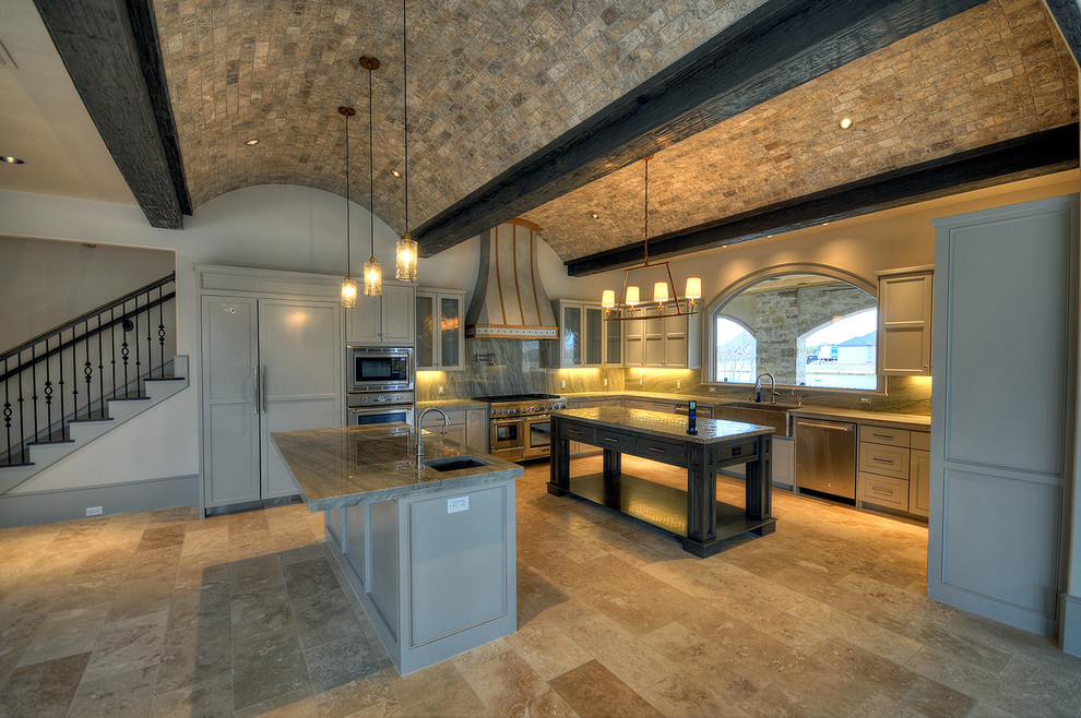 Inspiration för ett stort medelhavsstil kök, med luckor med infälld panel, grå skåp, marmorbänkskiva, en rustik diskho, grått stänkskydd, stänkskydd i sten, integrerade vitvaror, travertin golv, brunt golv och flera köksöar