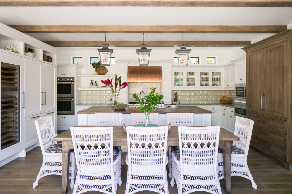 Inspiration for a large tropical u-shaped medium tone wood floor and brown floor eat-in kitchen remodel in Orange County with shaker cabinets, white cabinets, wood countertops, subway tile backsplash, stainless steel appliances, an island, brown countertops and beige backsplash