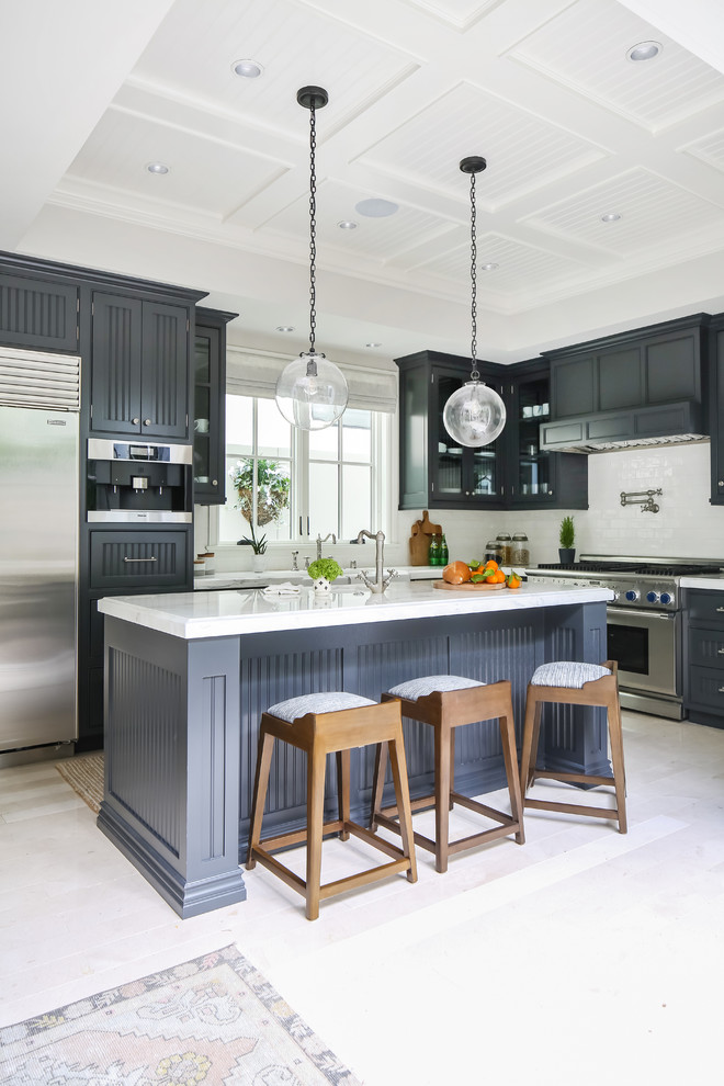 Inspiration for a transitional l-shaped white floor kitchen remodel in Orange County with gray cabinets, white backsplash, stainless steel appliances, an island, white countertops and recessed-panel cabinets
