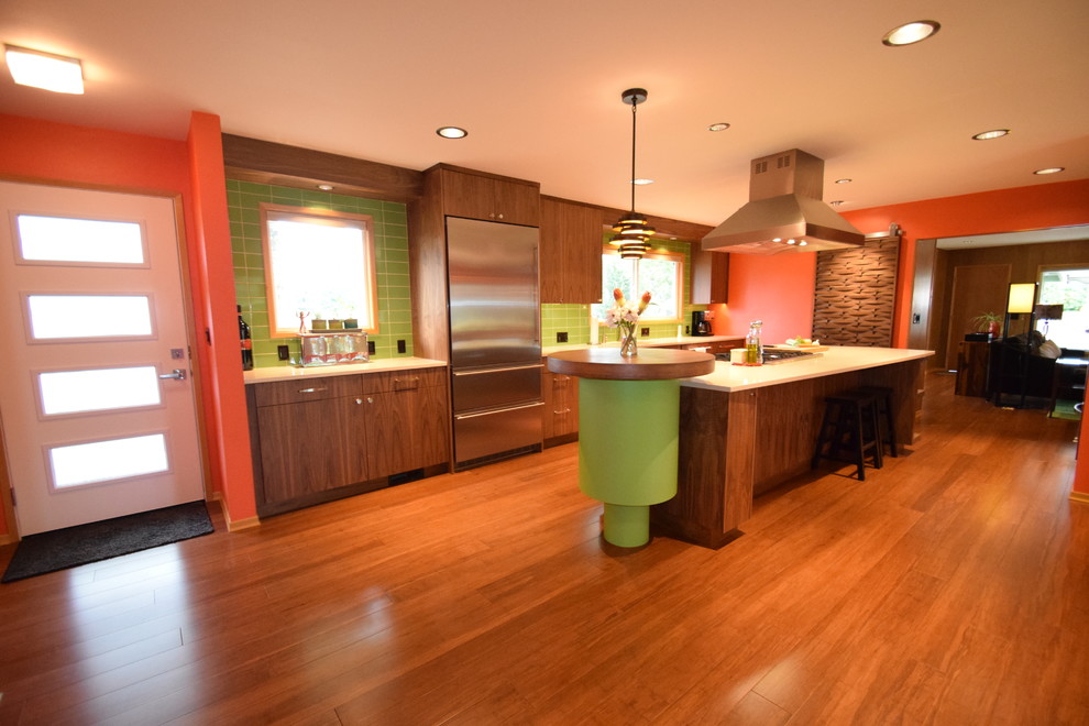 Eat-in kitchen - large 1960s galley bamboo floor and brown floor eat-in kitchen idea in Portland with an undermount sink, flat-panel cabinets, dark wood cabinets, quartz countertops, green backsplash, subway tile backsplash, stainless steel appliances and an island