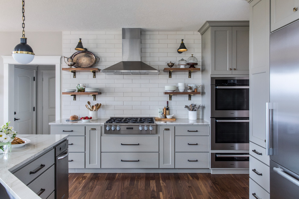 Design ideas for a large traditional u-shaped kitchen in Portland with a submerged sink, grey cabinets, engineered stone countertops, white splashback, ceramic splashback, stainless steel appliances, white worktops, shaker cabinets, dark hardwood flooring and brown floors.