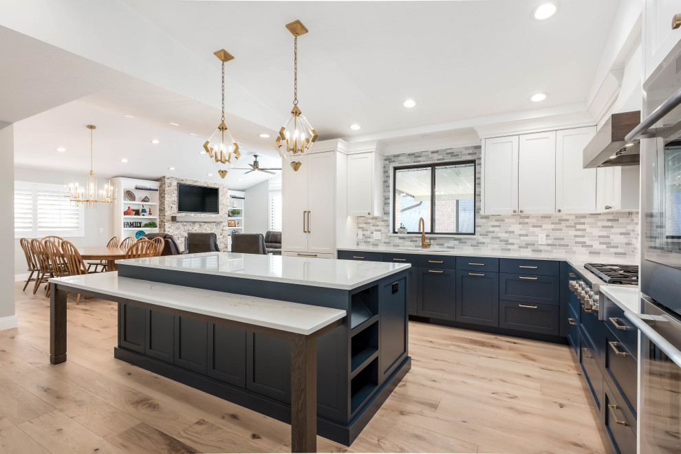 Mid-sized country light wood floor eat-in kitchen photo in Salt Lake City with an undermount sink, shaker cabinets, blue cabinets, quartz countertops, gray backsplash, paneled appliances, an island and white countertops