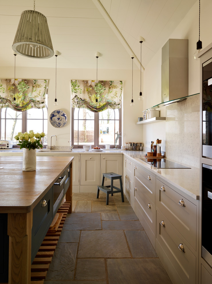 Photo of a large beach style grey and cream l-shaped open plan kitchen in Essex with grey cabinets, wood worktops and an island.
