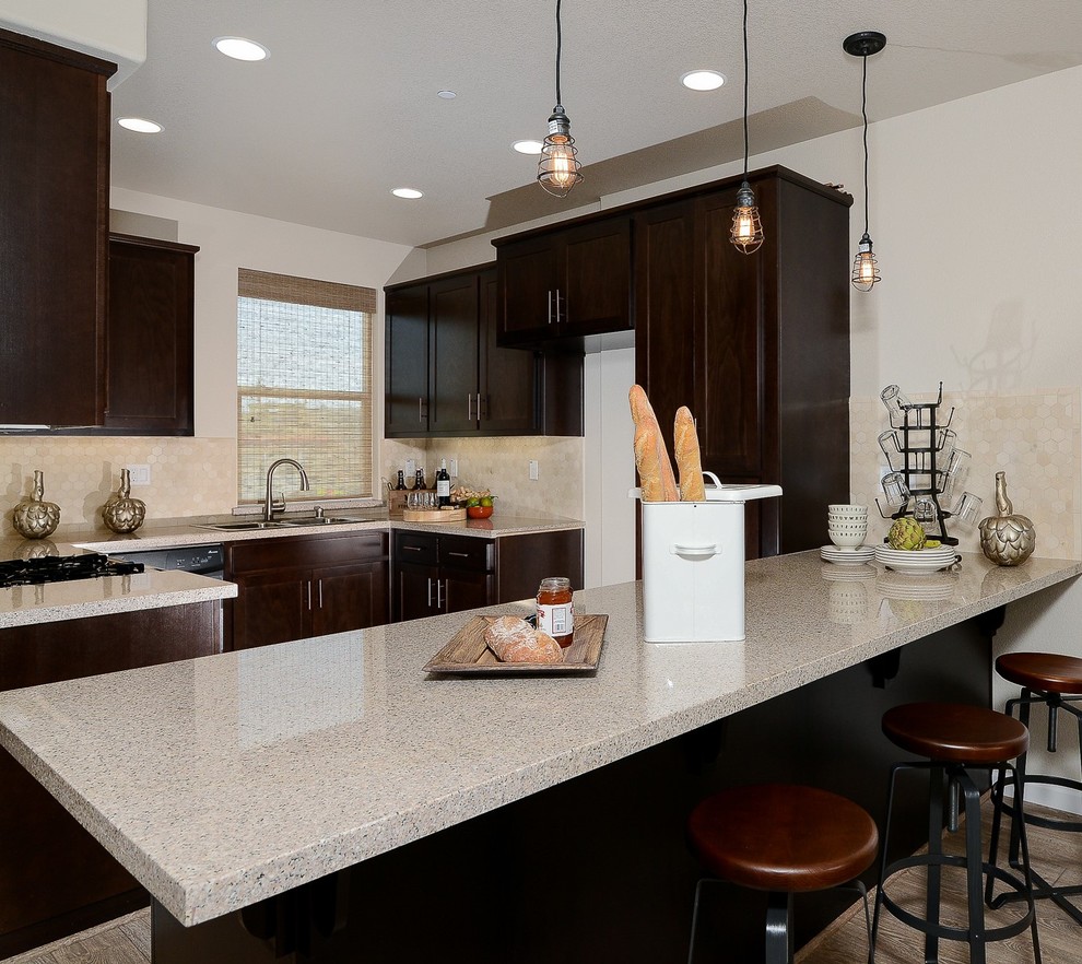 Example of a small urban u-shaped kitchen design in Sacramento with dark wood cabinets, granite countertops, beige backsplash, stone tile backsplash and an island