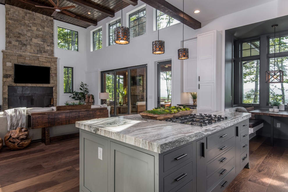 Example of a large mountain style dark wood floor and brown floor open concept kitchen design in Other with shaker cabinets, white cabinets, granite countertops, white backsplash, window backsplash, stainless steel appliances, an island and black countertops