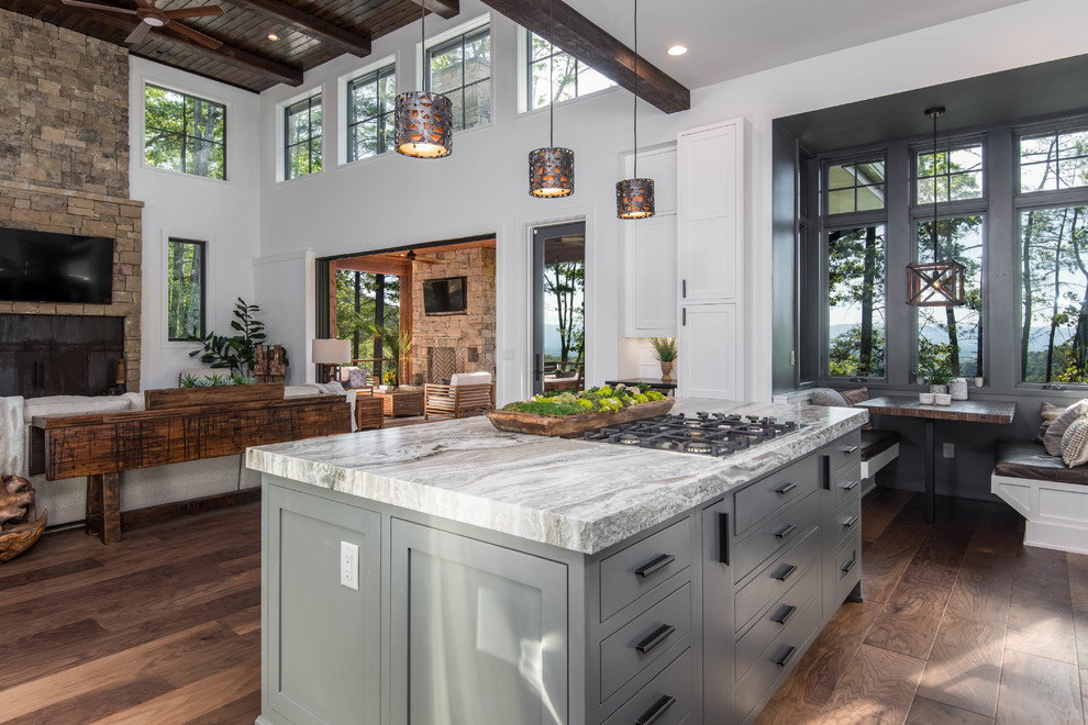 Large mountain style dark wood floor and brown floor open concept kitchen photo in Other with an undermount sink, shaker cabinets, white cabinets, granite countertops, white backsplash, window backsplash, stainless steel appliances, an island and black countertops