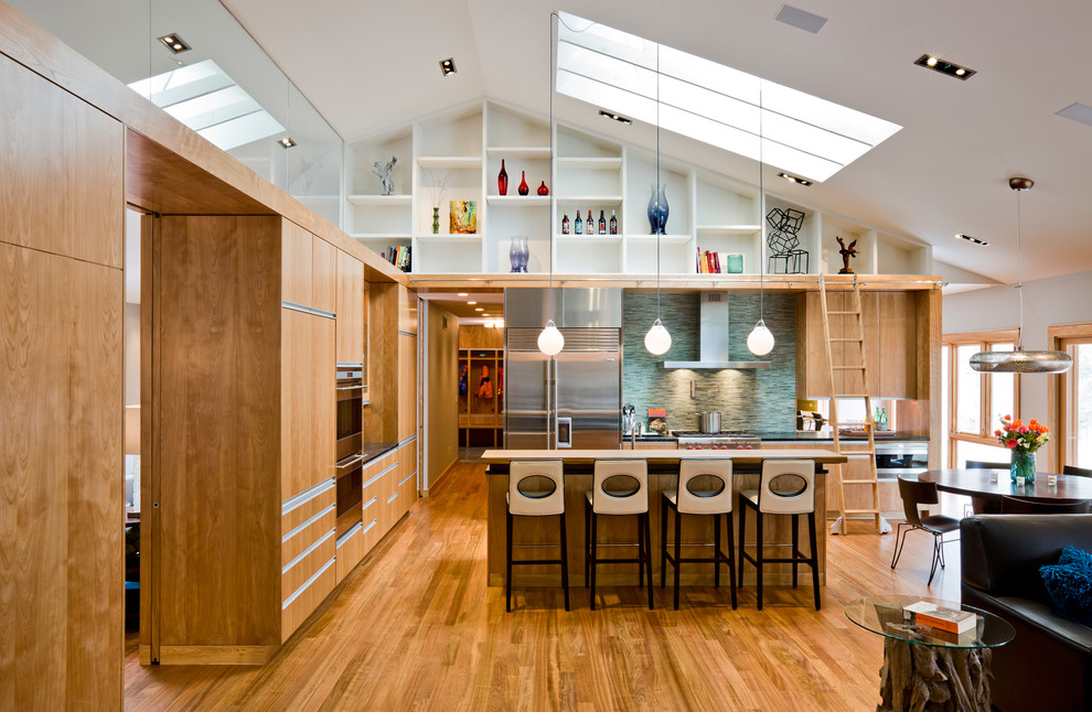 Inspiration for a modern open concept kitchen remodel in Minneapolis with stainless steel appliances, green backsplash, matchstick tile backsplash, flat-panel cabinets and light wood cabinets
