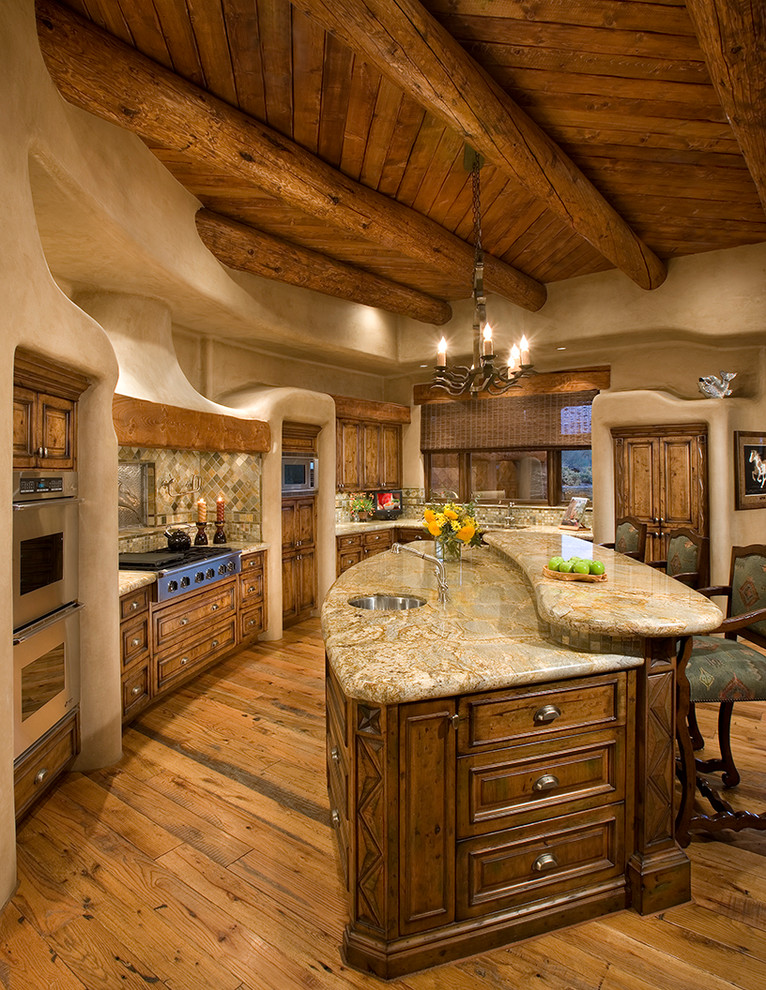 Cette photo montre une cuisine américaine sud-ouest américain en bois foncé avec un sol en bois brun, un électroménager en acier inoxydable et îlot.