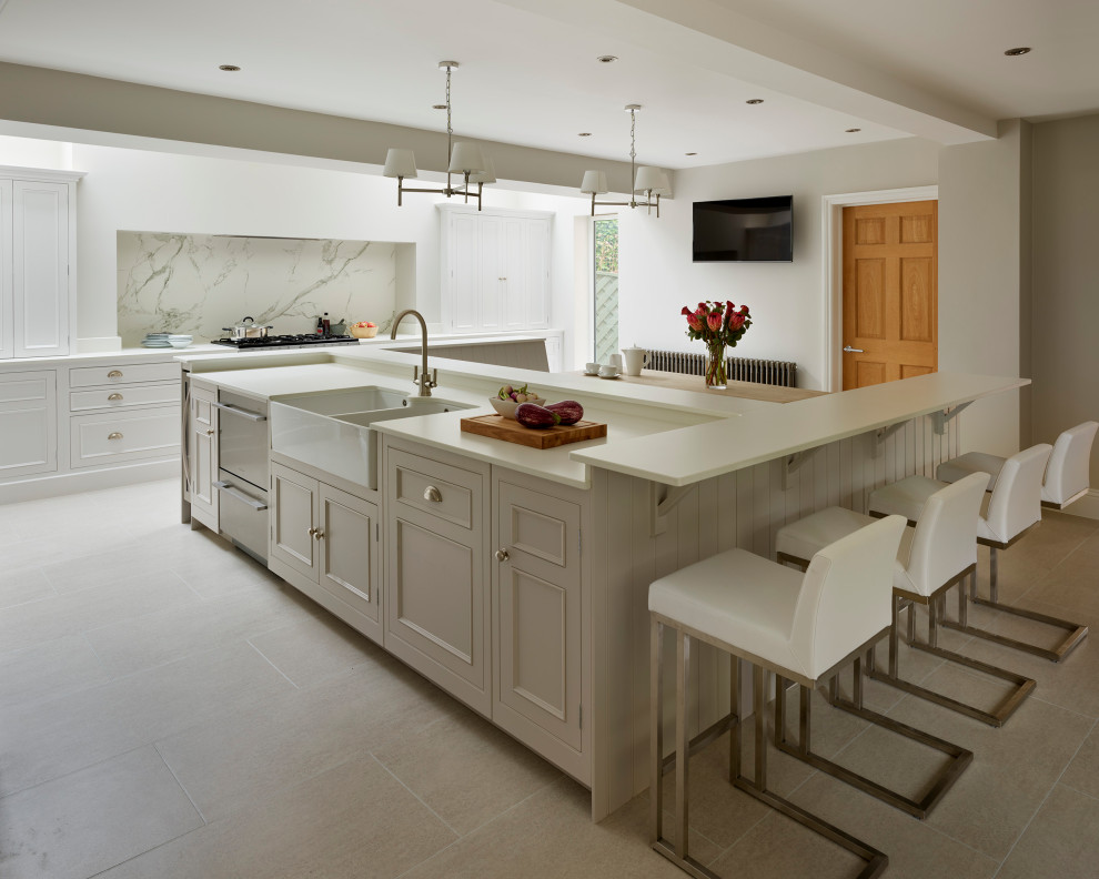 Foto på ett funkis vit kök med öppen planlösning, med rostfria vitvaror och en köksö