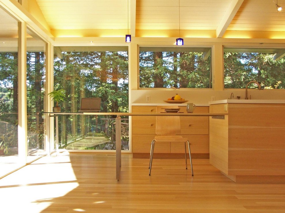 Immagine di una cucina moderna chiusa con ante lisce e ante in legno chiaro