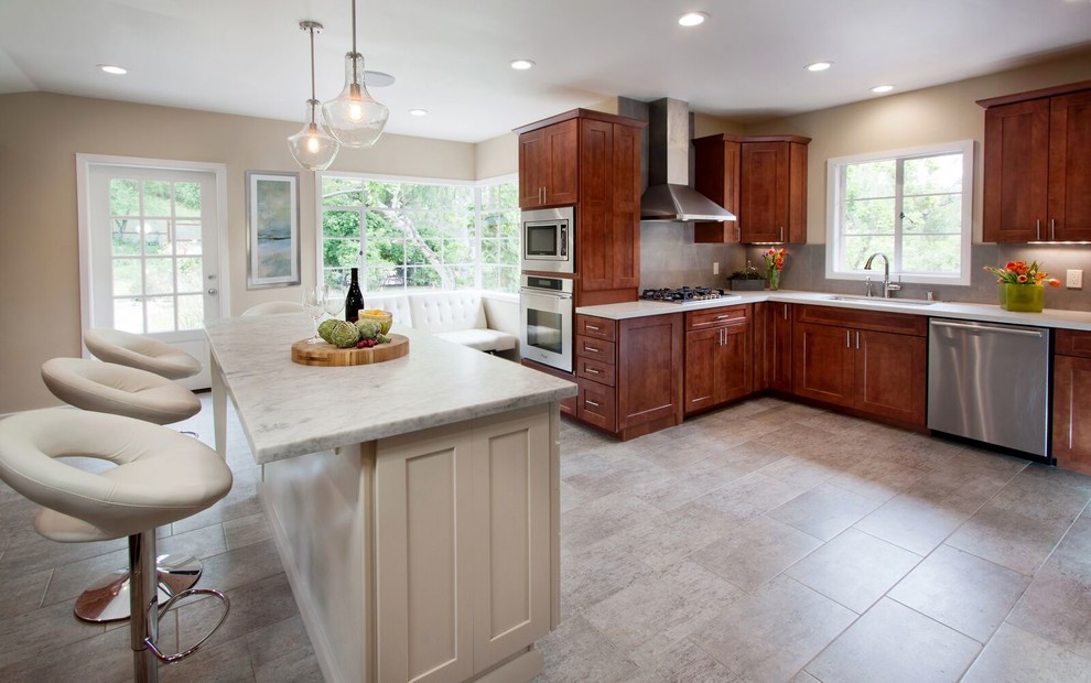 Inspiration for a large transitional u-shaped porcelain tile enclosed kitchen remodel in San Francisco with an undermount sink, shaker cabinets, white cabinets, quartz countertops, gray backsplash, porcelain backsplash, stainless steel appliances and an island
