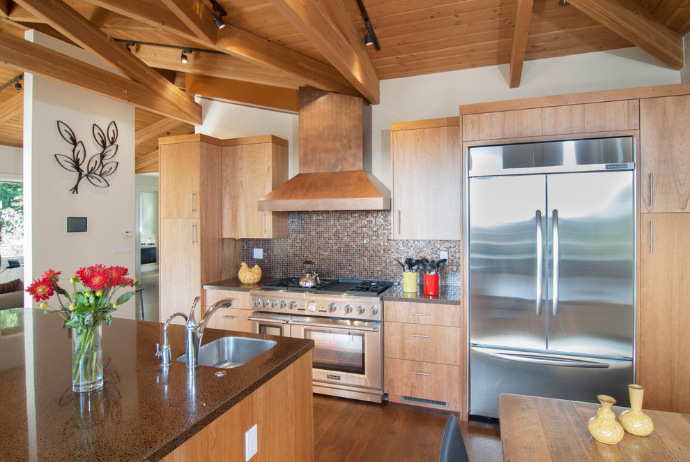 Example of a large trendy galley medium tone wood floor and brown floor eat-in kitchen design in San Francisco with light wood cabinets, stainless steel appliances, a drop-in sink, flat-panel cabinets, laminate countertops, metallic backsplash, glass tile backsplash and an island