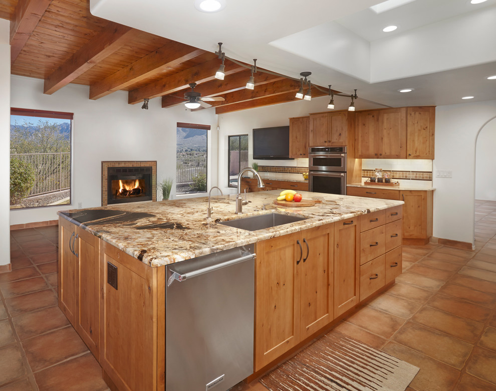 Foto på ett mycket stort amerikanskt brun kök, med en undermonterad diskho, luckor med infälld panel, skåp i ljust trä, granitbänkskiva, brunt stänkskydd, stänkskydd i glaskakel, rostfria vitvaror, klinkergolv i terrakotta, en köksö och brunt golv