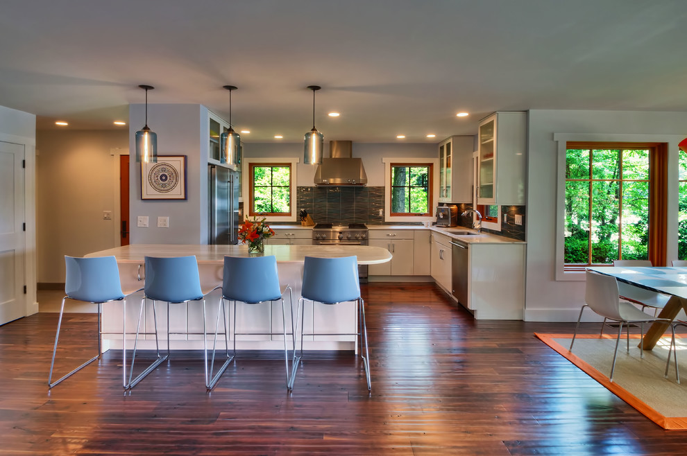 Eat-in kitchen - mid-sized craftsman u-shaped dark wood floor eat-in kitchen idea in New York with a drop-in sink, flat-panel cabinets, white cabinets, blue backsplash, ceramic backsplash and stainless steel appliances