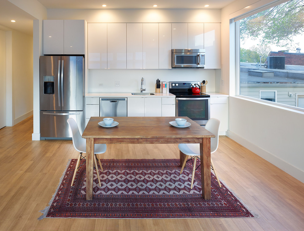 Einzeilige Moderne Wohnküche ohne Insel mit flächenbündigen Schrankfronten, weißen Schränken und Küchengeräten aus Edelstahl in Washington, D.C.