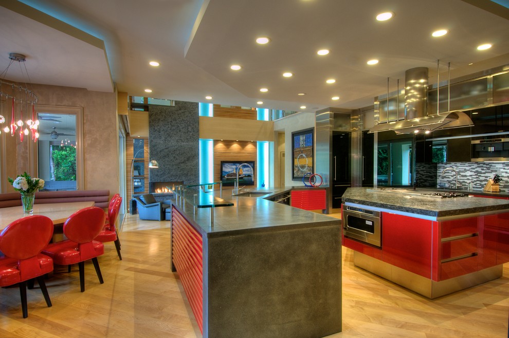 На фото: большая п-образная кухня в современном стиле с обеденным столом, красными фасадами, столешницей из бетона, разноцветным фартуком, фартуком из удлиненной плитки, светлым паркетным полом и островом с