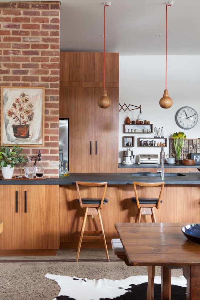Diseño de cocina comedor retro con fregadero integrado, armarios con paneles lisos, puertas de armario de madera oscura y electrodomésticos de acero inoxidable