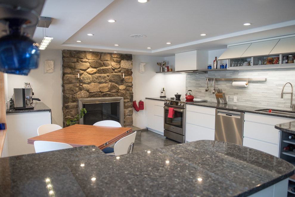Modern inredning av ett mellanstort kök, med en enkel diskho, släta luckor, vita skåp, grått stänkskydd, stänkskydd i stickkakel, rostfria vitvaror, klinkergolv i keramik och en halv köksö