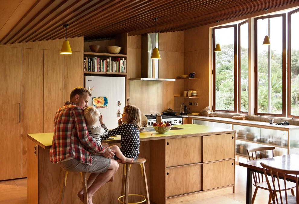 Moderne Wohnküche in L-Form mit offenen Schränken, hellbraunen Holzschränken, Küchengeräten aus Edelstahl, braunem Holzboden, Kücheninsel und gelber Arbeitsplatte in Auckland