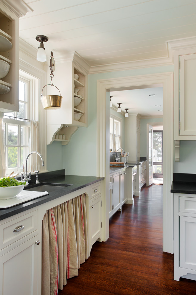Inspiration for a large coastal u-shaped medium tone wood floor enclosed kitchen remodel in Boston with an undermount sink, beaded inset cabinets, white cabinets, granite countertops, stainless steel appliances and an island