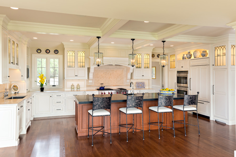 Photo of a large traditional u-shaped kitchen/diner in Boston with a submerged sink, raised-panel cabinets, white cabinets, stainless steel appliances, dark hardwood flooring and an island.