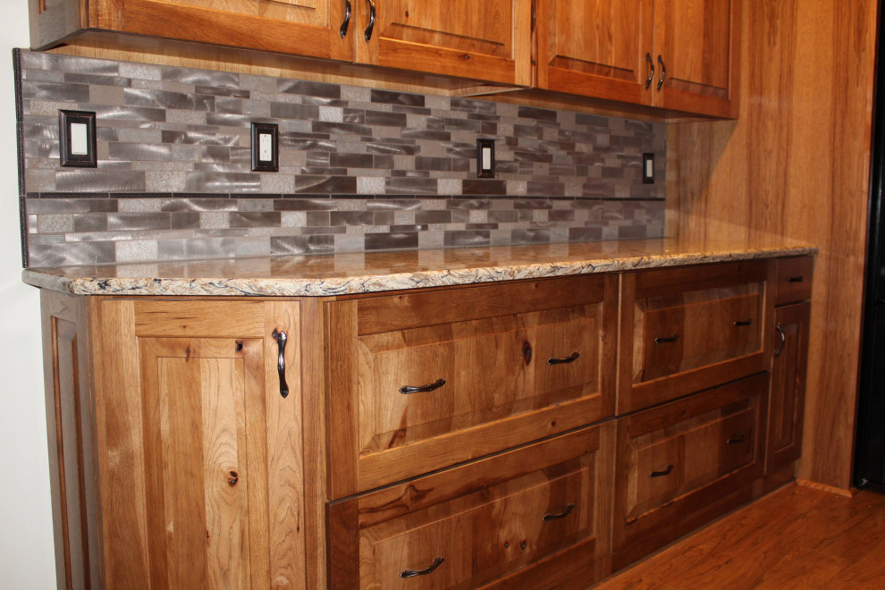 Exempel på ett stort rustikt brun brunt kök, med en undermonterad diskho, luckor med upphöjd panel, bänkskiva i kvartsit, stänkskydd med metallisk yta, svarta vitvaror, mellanmörkt trägolv, en köksö, brunt golv och skåp i mellenmörkt trä